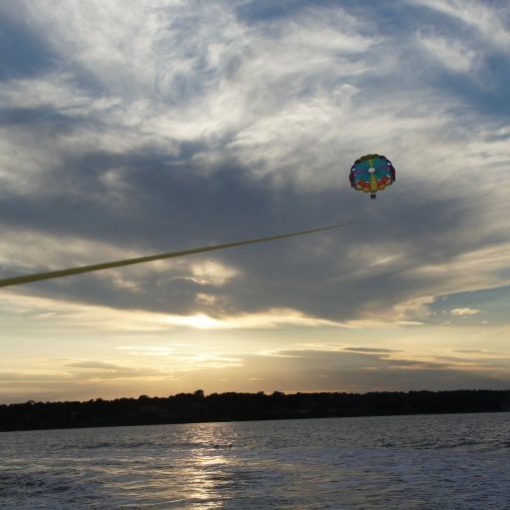 a person flying a kite in a large body of water