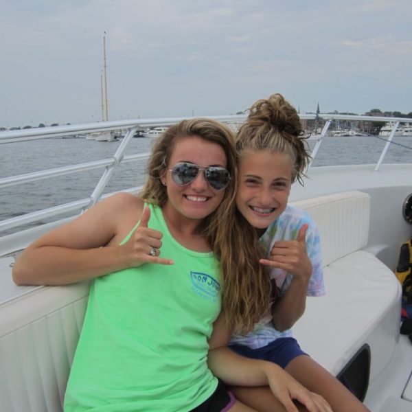 a woman sitting next to a body of water
