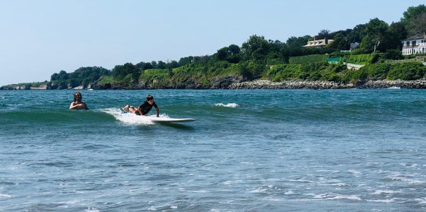 a group of people riding on the back of a boat in the water