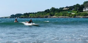 a group of people riding on the back of a boat in the water